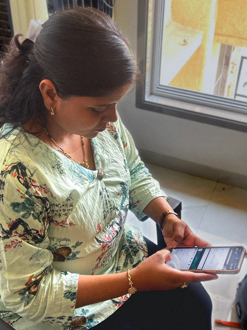 A Karya worker completing tasks on her phone at home