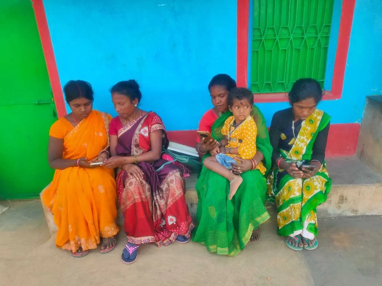 Karya workers seated together with their phones